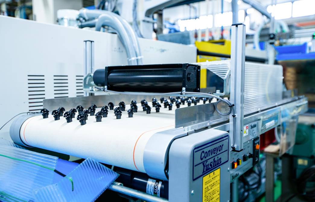 大量のウォッシャーノズルがコンベアーで流れている様子